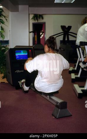 E-Street Gym-Frau, die an der Rudermaschine England trainiert Stockfoto