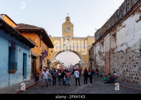 Antigua Guatemala, 5. april 2023: Stadtbild der Hauptstraße und gelber Santa Catalina Arch mit vielen Menschen, die um den ruhenden Semana santa laufen Stockfoto