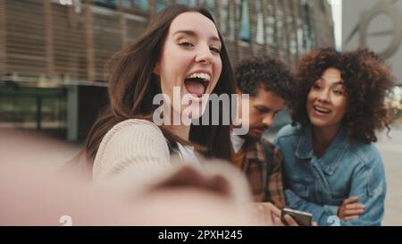 Nahaufnahme einer jungen Frau, die ein Selfie macht. Die Schülerin filmt mit ihren Freunden einen Stream auf einem Mobiltelefon Stockfoto