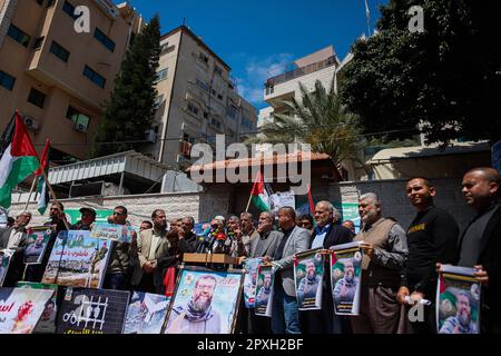 Gaza, Palästina. 02. Mai 2023. Die Menschen versammeln sich vor dem Gebäude des Internationalen Komitees vom Roten Kreuz (IKRK) in Gaza-Stadt, während sie das Poster des palästinensischen Gefangenen Khader Adnan halten, der nach einem 87-tägigen Hungerstreik in einem israelischen Gefängnis am 02. Mai 2023 starb. Khader Adnan trat als Reaktion auf seine administrative Inhaftierung 66 Tage im Jahr 2012, 52 Tage im Jahr 2015, 59 Tage im Jahr 2018 und 25 Tage im Jahr 2021 in den Hungerstreik. Foto: Ramez Habboub/ABACAPRESS.COM Kredit: Abaca Press/Alamy Live News Stockfoto