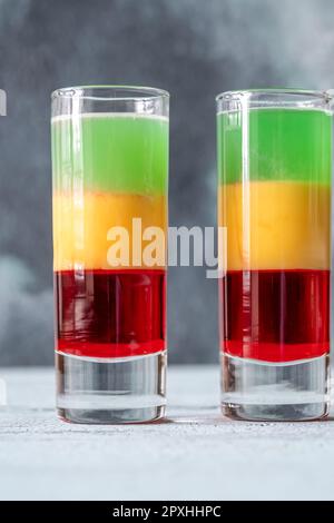 Mehrlagiger Squashed Frog Cocktail in Schnapsglas Stockfoto