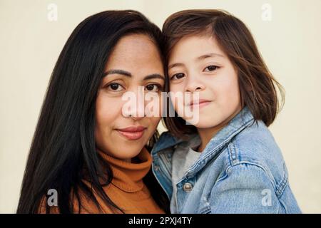 Glückliche asiatische Mutter und Tochter schauen in die Kamera - Familienliebeskonzept Stockfoto