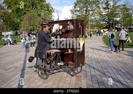 Straßenmusiker, der ein mobiles Klavier spielt, das er mit Fußtritten navigiert. Stratford upon Avon England Großbritannien. Straßenunterhalter Stockfoto