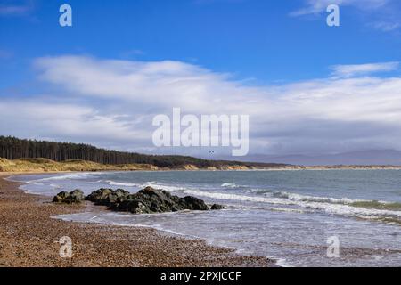 Felsen und Meer bei Flut am Newborough Beach von Llanddwyn Island Ende Newborough, Isle of Anglesey, Wales, Vereinigtes Königreich, Großbritannien Stockfoto