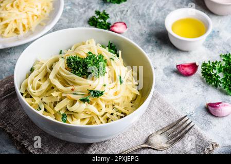 Einfache Mittagessen Rezept. Linguine Pasta mit Olivenöl, Knoblauch, frischer Petersilie und geriebenem Parmesankäse. Stockfoto