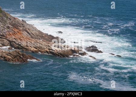 Das Meer im Tsitsikamma-Park mit turbulenten blauen und weißen Wellen, die gegen die Küste schlagen Stockfoto