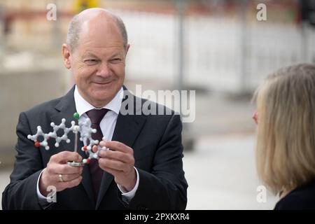 Ingelheim, Deutschland. 02. Mai 2023. Bundeskanzler Olaf Scholz (SPD) betrachtet während der bahnbrechenden Zeremonie für das Chemische Innovationswerk (CIP) von Boehringer Ingelheim ein Modell eines Empagliflozin-Moleküls, des Hauptbestandteils des Typ-2-Diabetes-Medikaments Jardiance. Im neuen Werk wird Boehringer Ingelheim neue chemische Herstellungsverfahren für innovative pharmazeutische Wirkstoffe entwickeln. Kredit: Sebastian Christoph Gollnow/dpa/Alamy Live News Stockfoto