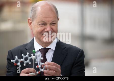 Ingelheim, Deutschland. 02. Mai 2023. Bundeskanzler Olaf Scholz (SPD) betrachtet während der bahnbrechenden Zeremonie für das Chemische Innovationswerk (CIP) von Boehringer Ingelheim ein Modell eines Empagliflozin-Moleküls, des Hauptbestandteils des Typ-2-Diabetes-Medikaments Jardiance. Im neuen Werk wird Boehringer Ingelheim neue chemische Herstellungsverfahren für innovative pharmazeutische Wirkstoffe entwickeln. Kredit: Sebastian Christoph Gollnow/dpa/Alamy Live News Stockfoto