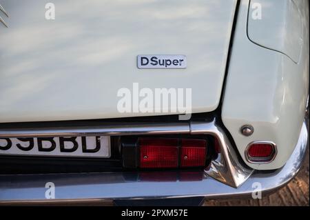 Detail eines wunderschönen französischen Klassikers, der Citroen DS D Super in Weiß. Detaildarstellung der Rückleuchte und des Emblems mit silbernen Buchstaben Stockfoto