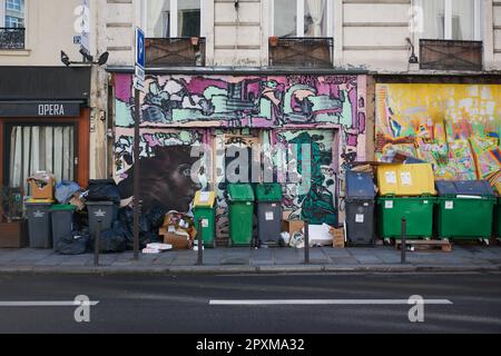 Müll wird in Paris vor Graffiti hoch gestapelt Stockfoto