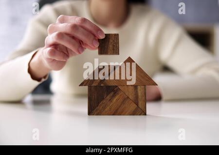 Woman Building House Mit Holztangram Puzzle Stockfoto