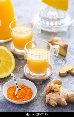 Hausgemachte Kurkuma Zitrone Ingwer Shots in kleinen Gläsern, gesunde Ingwer Zitrone Kurkuma Shot – ideal, um das Immunsystem im Winter zu stärken Stockfoto