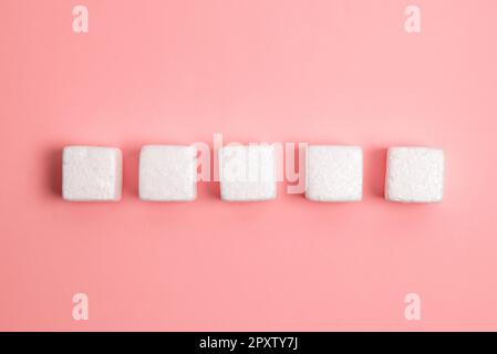 Weiße Styroporwürfel auf dem farbigen Schreibtisch. Brandneue Informationen. Stockfoto