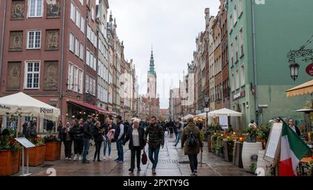 Menschen gehen durch die Altstadt von Danzig vor dem Rathaus. Stockfoto