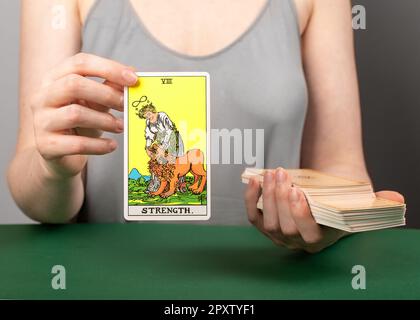 Lodz Poland 15 2023. April Strength Arcana, Handhalter zeigt Tarotkarte während der Enthüllung. Stockfoto