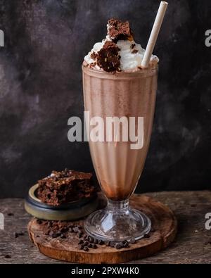 Ein köstlicher Schokoladenmilchshake garniert mit Stücken Schokoladenteig Stockfoto