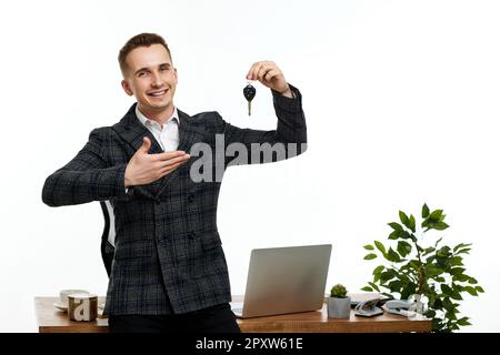 Erfolgreicher weißer, fröhlicher Mann mit einem Schlüssel Stockfoto