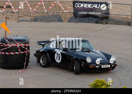 Duncan Buck tritt gegen einen klassischen Porsche 911 aus dem Jahr 1980er an der Corbeau Seats Rallye an der Küste in Clacton, Essex, Großbritannien. Mitfahrerin Catherine Buck Stockfoto