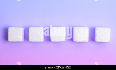 Weiße Styroporwürfel auf dem farbigen Schreibtisch. Brandneue Informationen. Stockfoto