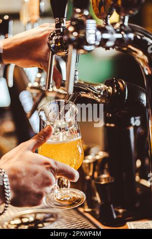 Eine verkürzte Hand Barkeeper, der Bier vom Fass an der Bar auffüllte. Stockfoto