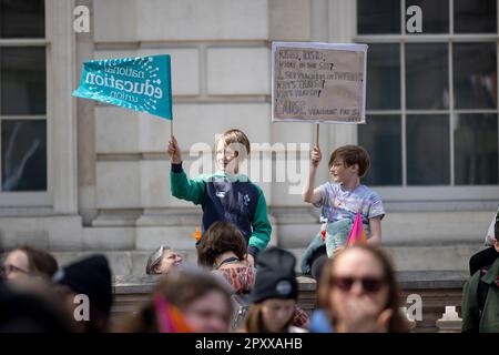 London, Großbritannien. 02. Mai 2023. Kinder von Lehrern der Nationalen Bildungsunion halten ein Plakat und schwenken während der Demonstration am Tag der NEU-Arbeitskampagne in der Downing Street eine Flagge. Tausende von Lehrermitgliedern der National Education Union haben heute eine Arbeitsklage im Lohnstreit mit der britischen Regierung abgehalten. Sie marschierten vom London Eye zum Bildungsministerium, um einen Petitionsbrief abzugeben, und später zur Downing Street. Kredit: SOPA Images Limited/Alamy Live News Stockfoto