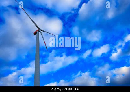 Windkraftanlage gegen einen lebendigen blauen Himmel mit Wolken in Deutschland Stockfoto