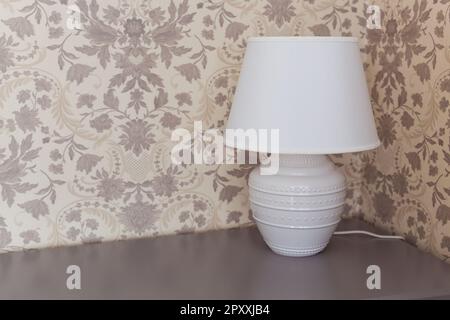 Weiße Lampe am Nachttisch. Innen. Stockfoto