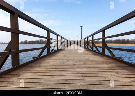 Ein hölzerner Pier mit blauem Himmel und Wolken Stockfoto