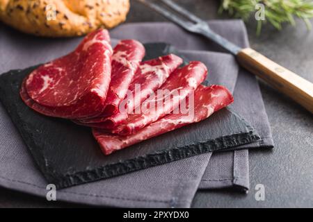 Geräucherte Bresaola. Italienische Vorspeise. Getrocknetes Rindfleisch auf dem Schneidebrett. Stockfoto