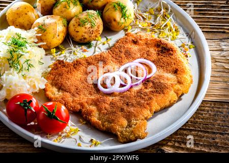 Schweinspanierte Kotelett mit Paniermehl überzogen, serviert mit Kartoffeln und Kohl Stockfoto