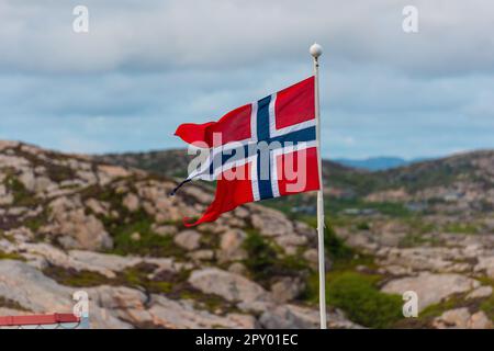 Lindesnes, Norwegen - August 08 2021: Große norwegische Flagge, die im Wind weht. Stockfoto