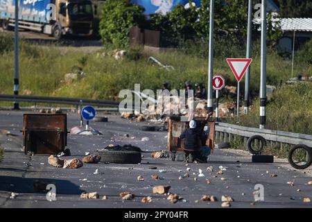 Ramallah, in der Nähe der jüdischen Siedlung Beit El, im besetzten Westjordanland am 02. Mai 2023. Palästinensische Jugendliche werfen Steine während der Zusammenstöße mit israelischen Soldaten nach dem Tod des palästinensischen Gefangenen Khader Adnan, der nach einem 87-tägigen Hungerstreik in einem israelischen Gefängnis am nördlichen Eingang der Stadt Ramallah, in der Nähe der jüdischen Siedlung Beit El, starb. Im besetzten Westjordanland am 02. Mai 2023. Kredit: UPI/Alamy Live News Stockfoto