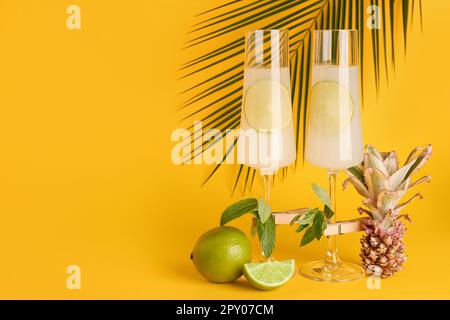 Gläser Cocktail mit Limette, Minze und Ananas auf gelbem Hintergrund Stockfoto
