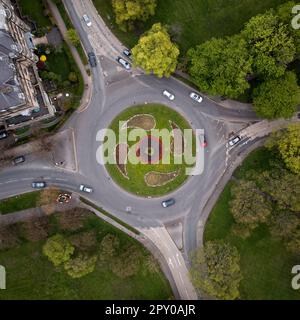 Blick aus der Vogelperspektive direkt über einem Kreisverkehr in Harrogate, North Yorkshire, mit landschaftlich gestalteten Blumenbeeten auf dem Spring Floral Trail Stockfoto