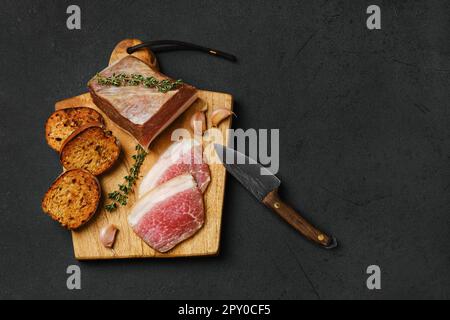 Draufsicht von gesalzenem Schweinebauch mit Schmalz auf Holzbrett Stockfoto