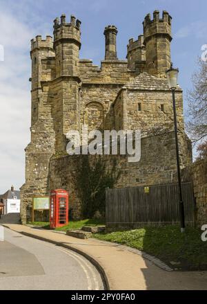 Die öffentliche Telefonzelle von Red British vor Battle Abbey, eine teilweise zerstörte Benediktinerabtei in Battle, East Sussex, England Stockfoto