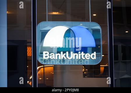 New York, NY - 26. April 2023 : BankUnited, Inc. Logo von Konsumenten- und Firmenkunden-Banking im Geschäftsfenster von Midtown, Manhattan Stockfoto