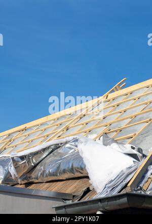 Wärmedämmung des Hauses mit Mineralwolle, Dachisoliertechnik. Bau altes Dach vom blauen Himmel des Hauses Stockfoto