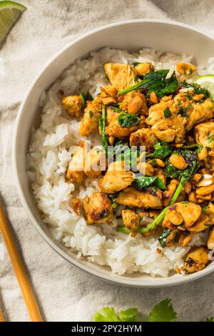 Asiatisches Ingwer-Erdnuss-Hühnchen und Reis mit Limone und Kräutern Stockfoto