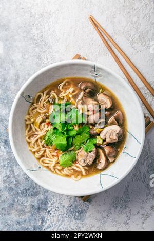 Asiatische vegane Ramen-Nudelsuppe mit Pilzen, Zwiebeln und Koriander Stockfoto
