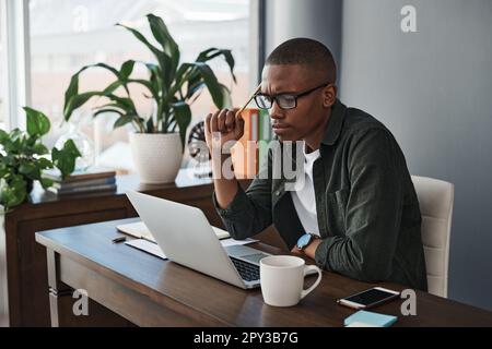 Ideen im Wert von einer Million Dollar ausdenken. Ein junger Geschäftsmann, der von zu Hause aus arbeitet. Stockfoto