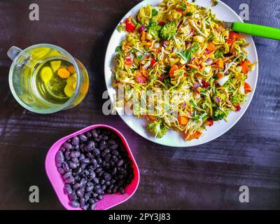 Gemüsesuppe mit Bohnen, Grün, Reis, Nudeln, Zwiebeln, Tomaten und Knoblauch auf einem weißen Teller mit Gabel oder Löffel in Mexiko. Stockfoto