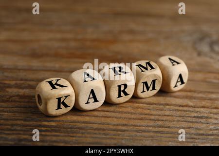 Wort Karma aus Würfeln mit Buchstaben auf einem Holztisch Stockfoto