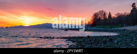 English Bay Beach in Downtown Vancouver, British Columbia, Kanada. Dramatischer Sonnenuntergang an der Westküste des Pazifischen Ozeans. Panorama-Hintergrund Stockfoto