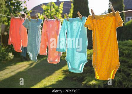 Babykleidung trocknet an der Wäscheleine im Freien Stockfoto