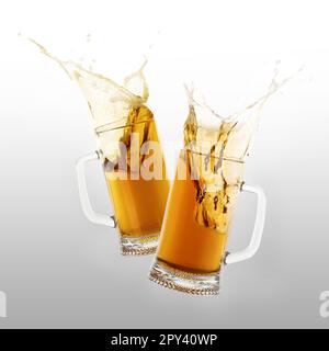 Zwei Gläser Bier zum Toasten mit Farbspritzern auf dem Hintergrund Stockfoto