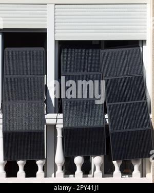 Sonnenlicht auf dem Balkon Solarzellen an der Fensterfront für die Photovoltaik-Energie des Haushalts Stockfoto