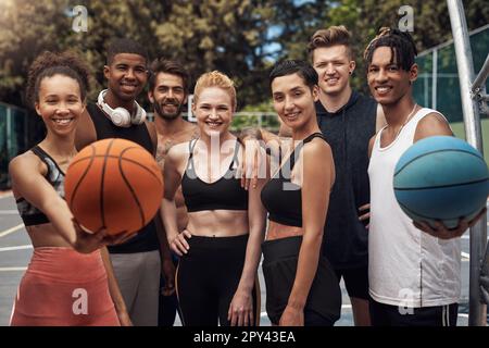 Die Teilnahme am Jugend-Basketball ist eine unterhaltsame Möglichkeit, Freundschaften zu schließen. Porträt einer Gruppe sportlicher Jugendlicher, die auf einem Sportplatz zusammenstehen. Stockfoto