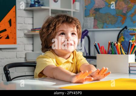Kind in der Nähe einer Tafel im Klassenzimmer. Bildungsprozess. Kinder machen sich bereit für die Schule. Stockfoto
