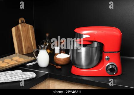 Moderner roter Standmixer und Zutaten auf der Arbeitsfläche in der Küche Stockfoto